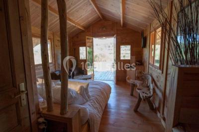 Salle de réception avec une longue table dressée, nappes blanches, vaisselle élégante et décorations florales.