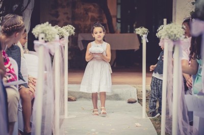 Miniature Location salle Méounes-lès-Montrieux (Var) - La Source #19 Une jeune fille en robe blanche porte un coussin sur une allée décorée lors d'une cérémonie en plein air.