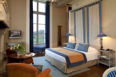 Clocher en pierre avec toit en ardoise sous un ciel bleu, la lune visible en arrière-plan.