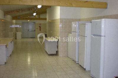 Schéma d'un bâtiment avec une grande salle centrale, quatre petites salles et trois entrées distinctes indiquées.