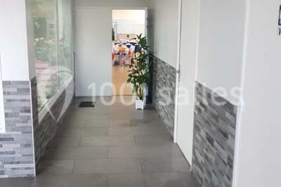 Schéma d'un bâtiment avec une grande salle centrale, quatre petites salles et trois entrées distinctes indiquées.