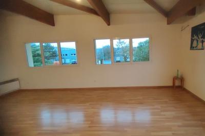 Schéma d'un bâtiment avec une grande salle centrale, quatre petites salles et trois entrées distinctes indiquées.