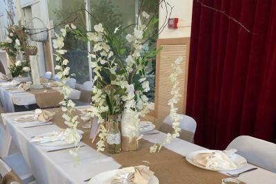 Schéma d'un bâtiment avec une grande salle centrale, quatre petites salles et trois entrées distinctes indiquées.