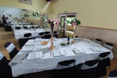 Schéma d'un bâtiment avec une grande salle centrale, quatre petites salles et trois entrées distinctes indiquées.