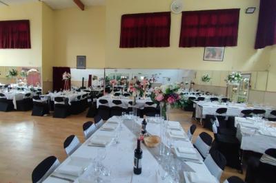 Schéma d'un bâtiment avec une grande salle centrale, quatre petites salles et trois entrées distinctes indiquées.