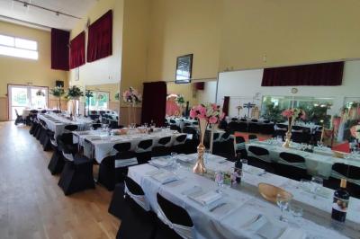 Schéma d'un bâtiment avec une grande salle centrale, quatre petites salles et trois entrées distinctes indiquées.