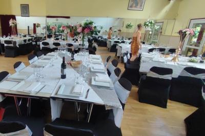 Schéma d'un bâtiment avec une grande salle centrale, quatre petites salles et trois entrées distinctes indiquées.