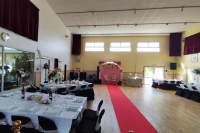 Schéma d'un bâtiment avec une grande salle centrale, quatre petites salles et trois entrées distinctes indiquées.