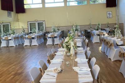 Schéma d'un bâtiment avec une grande salle centrale, quatre petites salles et trois entrées distinctes indiquées.