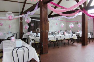 Cuisine simple avec évier en inox, étagères mobiles, cuisinière blanche et sol en carrelage rouge.