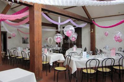 Cuisine simple avec évier en inox, étagères mobiles, cuisinière blanche et sol en carrelage rouge.