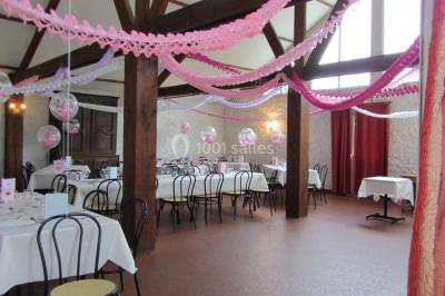 Cuisine simple avec évier en inox, étagères mobiles, cuisinière blanche et sol en carrelage rouge.