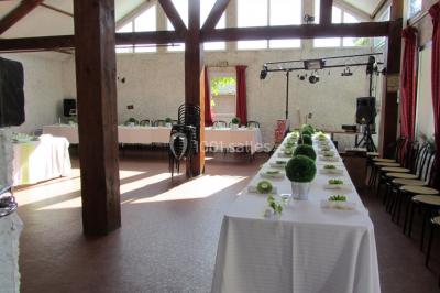 Cuisine simple avec évier en inox, étagères mobiles, cuisinière blanche et sol en carrelage rouge.