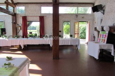 Cuisine simple avec évier en inox, étagères mobiles, cuisinière blanche et sol en carrelage rouge.