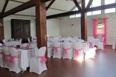 Cuisine simple avec évier en inox, étagères mobiles, cuisinière blanche et sol en carrelage rouge.