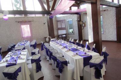 Cuisine simple avec évier en inox, étagères mobiles, cuisinière blanche et sol en carrelage rouge.