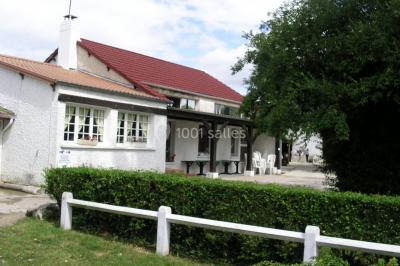 Cuisine simple avec évier en inox, étagères mobiles, cuisinière blanche et sol en carrelage rouge.
