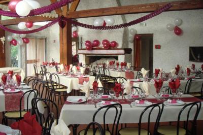 Cuisine simple avec évier en inox, étagères mobiles, cuisinière blanche et sol en carrelage rouge.