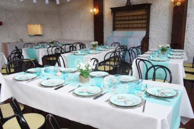 Cuisine simple avec évier en inox, étagères mobiles, cuisinière blanche et sol en carrelage rouge.