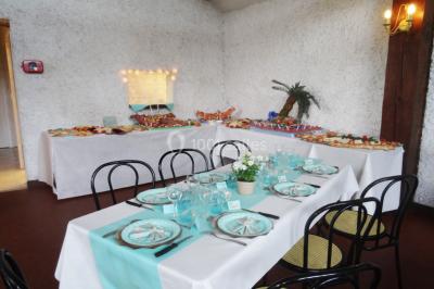 Cuisine simple avec évier en inox, étagères mobiles, cuisinière blanche et sol en carrelage rouge.