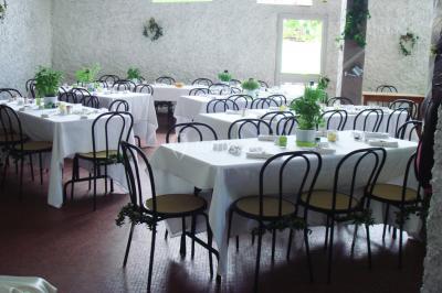 Cuisine simple avec évier en inox, étagères mobiles, cuisinière blanche et sol en carrelage rouge.