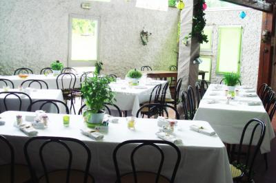 Cuisine simple avec évier en inox, étagères mobiles, cuisinière blanche et sol en carrelage rouge.