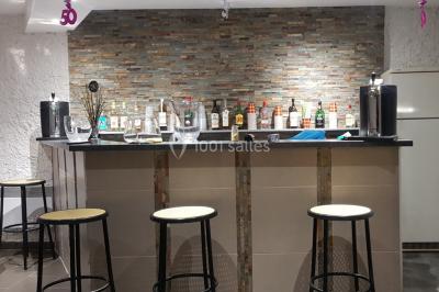 Cuisine simple avec évier en inox, étagères mobiles, cuisinière blanche et sol en carrelage rouge.