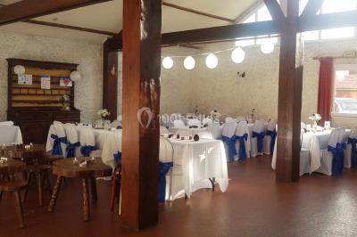 Cuisine simple avec évier en inox, étagères mobiles, cuisinière blanche et sol en carrelage rouge.