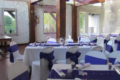 Cuisine simple avec évier en inox, étagères mobiles, cuisinière blanche et sol en carrelage rouge.