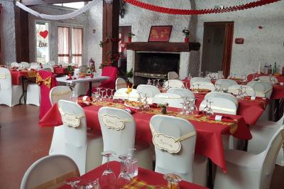 Cuisine simple avec évier en inox, étagères mobiles, cuisinière blanche et sol en carrelage rouge.