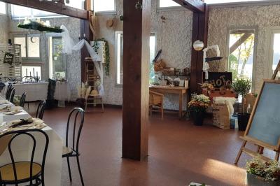 Cuisine simple avec évier en inox, étagères mobiles, cuisinière blanche et sol en carrelage rouge.