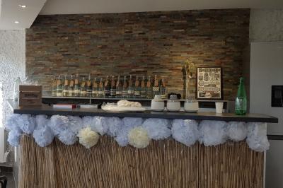 Cuisine simple avec évier en inox, étagères mobiles, cuisinière blanche et sol en carrelage rouge.