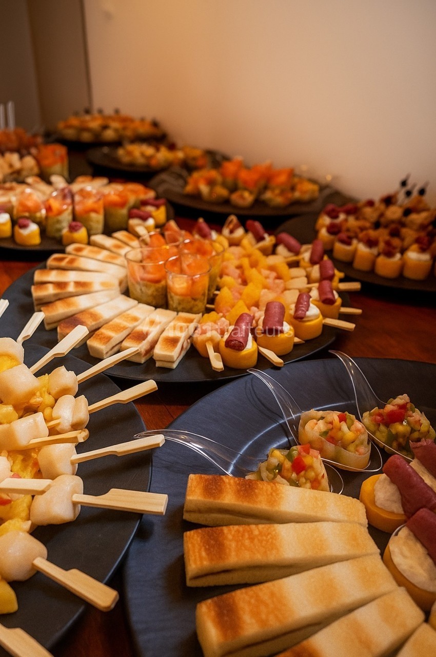 Plateaux de bouchées apéritives variées, comprenant brochettes, verrines et toasts, disposés sur une table en bois.
