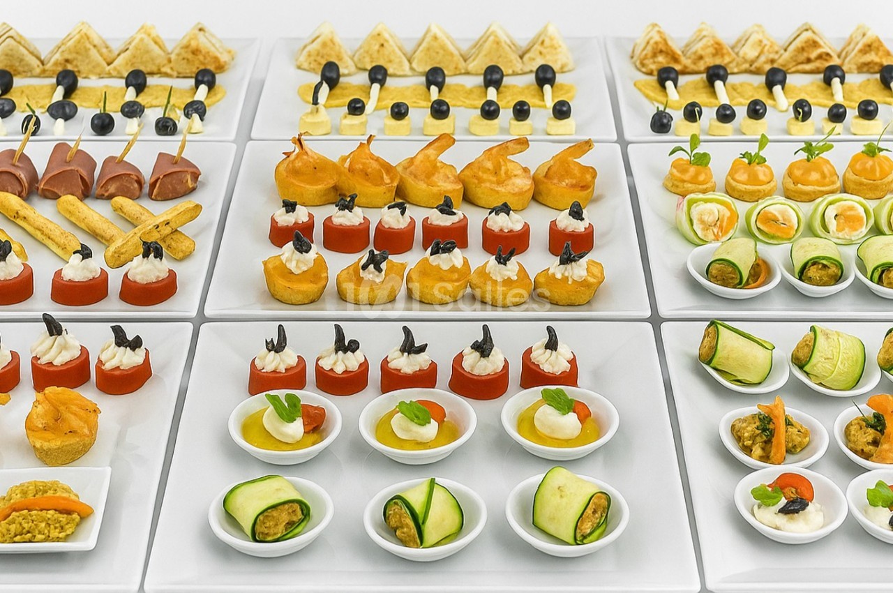 Plateau de canapés variés comprenant légumes, fromages, viandes et poissons, présentés de manière soignée.