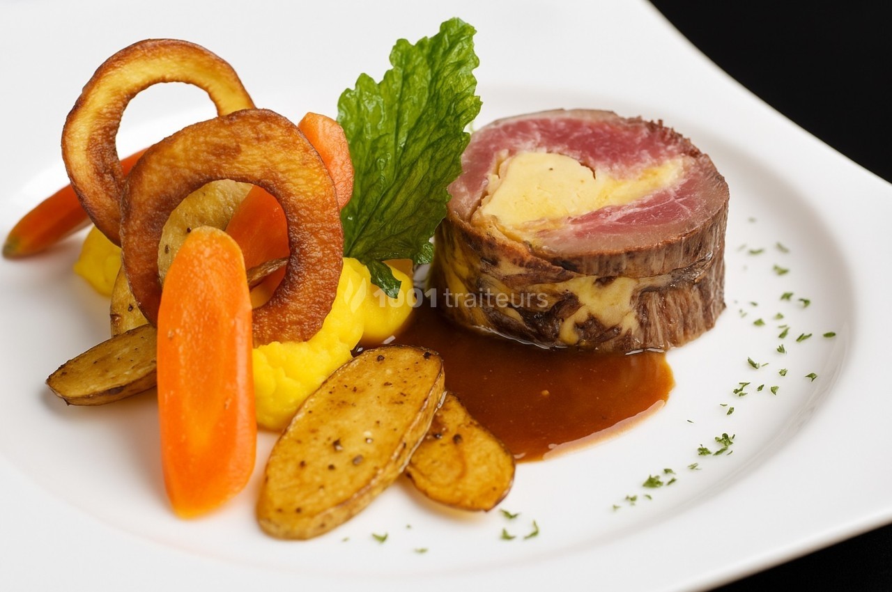Assiette gastronomique avec filet de bœuf, purée, carottes, pommes de terre rôties, chips et sauce brune.