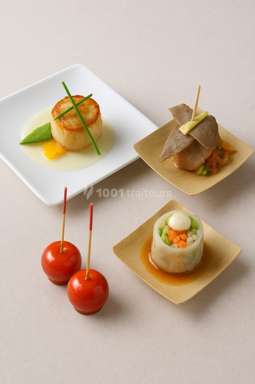 Assortiment de bouchées gastronomiques comprenant noix de Saint-Jacques, légumes roulés, viande et billes enrobées.