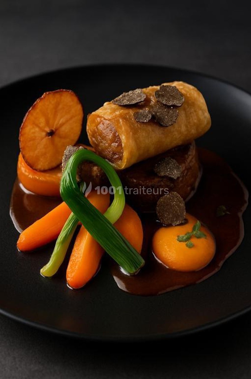 Plat gastronomique composé de viande, roulé croustillant, tranches de truffe, purée, carottes et pomme sur sauce brune.