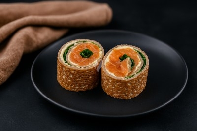 Assiette gastronomique avec tranches de poisson, agrumes, radis, croustillant décoratif et points de sauce balsamique.