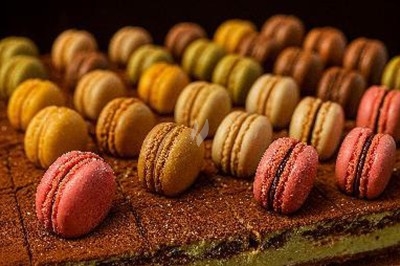 Assiette gastronomique avec tranches de poisson, agrumes, radis, croustillant décoratif et points de sauce balsamique.