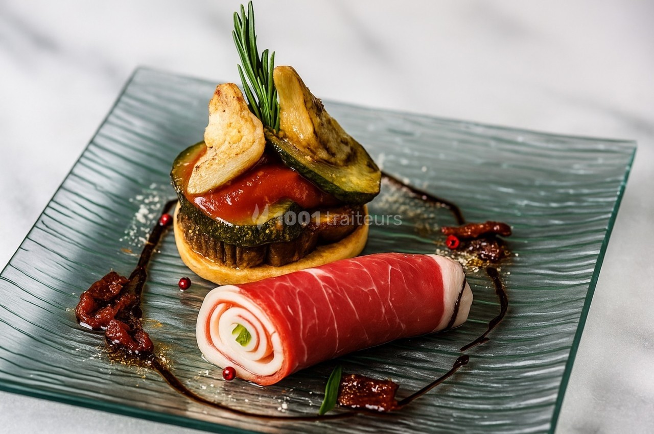 Assiette gastronomique avec roulé de jambon cru, légumes grillés, purée de tomate et décoration de romarin.
