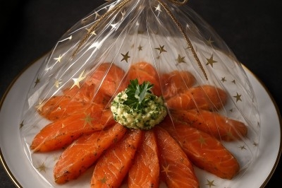 Assiette gastronomique avec tranches de poisson, agrumes, radis, croustillant décoratif et points de sauce balsamique.