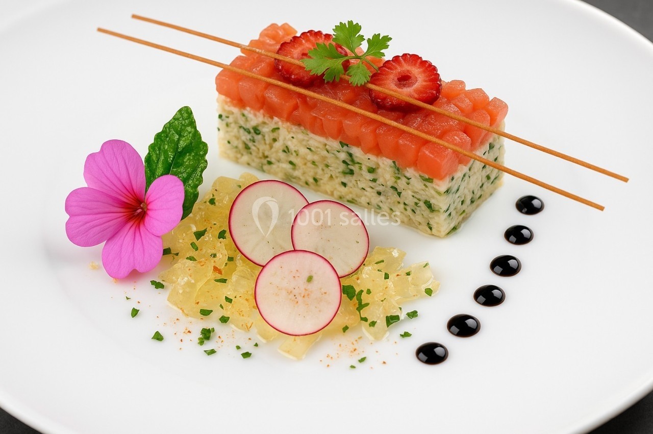 Plat gastronomique composé de tartare de saumon, radis, gelée, fleur comestible et sauce balsamique décorative.