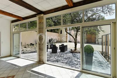 Salle de conférence moderne avec estrade, pupitre transparent, chaises blanches et rangées de sièges vides.