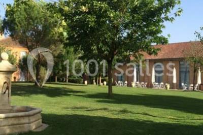 Jardin avec pelouse, arbres et pot en terre cuite au premier plan, éclairé par une lumière douce en fin de journée.