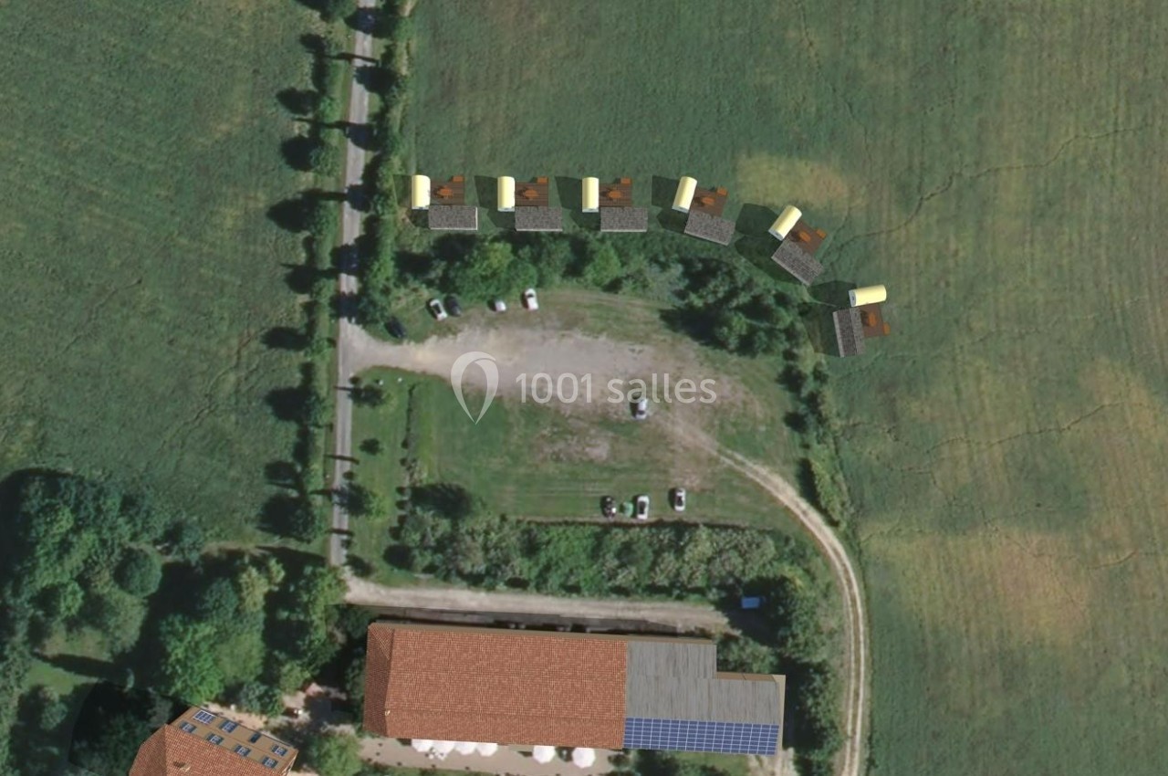 Location salle Monferran-Savès (Gers) - Le Meillon #26 Vue aérienne d'un terrain avec des bâtiments, des véhicules stationnés et des structures alignées en bordure d'un champ.