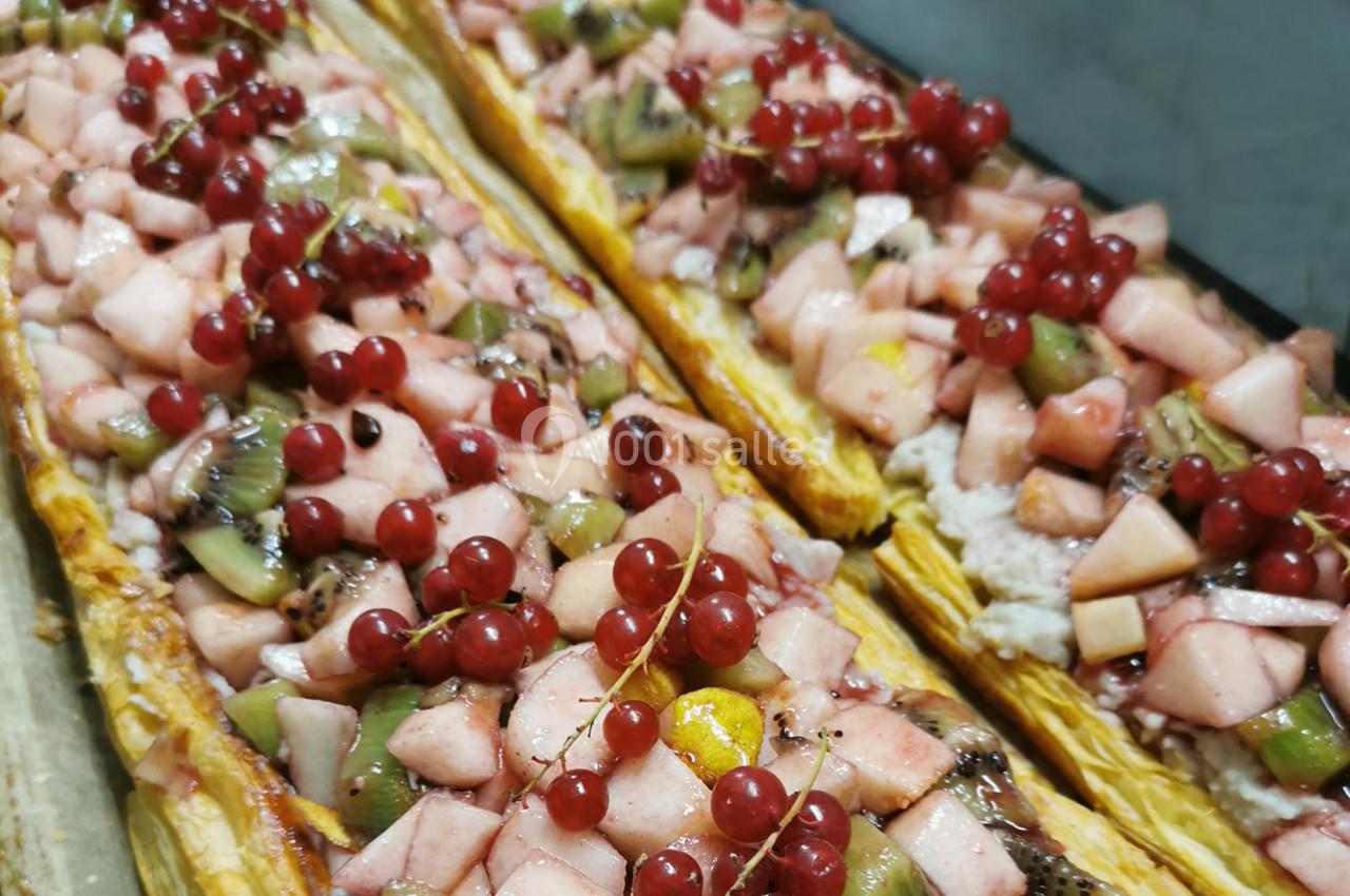 Tartes aux fruits garnies de pommes, kiwis et groseilles rouges sur une pâte feuilletée dorée.