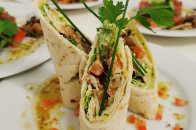 Assiette de salade composée avec melon, tomate, mozzarella, herbes fraîches et décoration florale, accompagnée de toasts et…