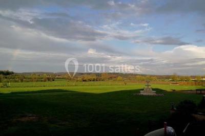 Salle de bain avec une douche à rideau blanc et violet, un lavabo avec serviettes pliées et un miroir mural.