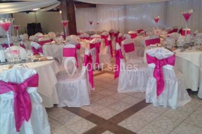 Salle de bain avec une douche à rideau blanc et violet, un lavabo avec serviettes pliées et un miroir mural.