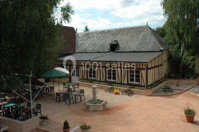 Salle de bain avec une douche à rideau blanc et violet, un lavabo avec serviettes pliées et un miroir mural.